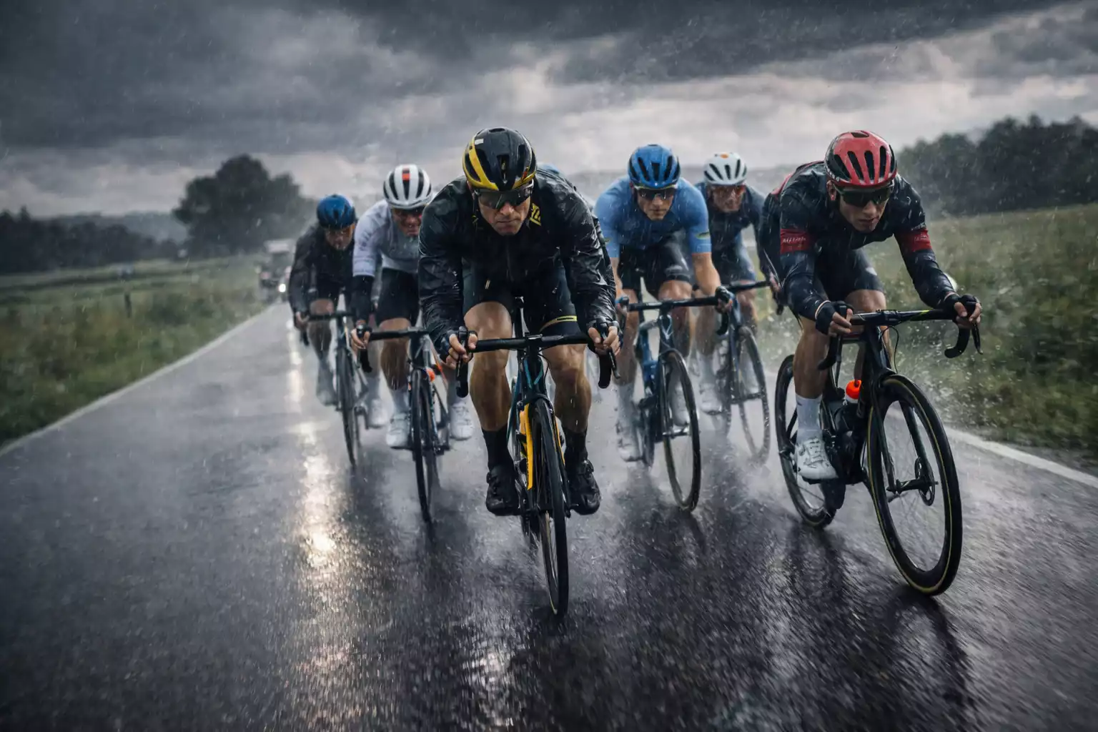 Wielrenners rijden door de regen tijdens zware weersomstandigheden